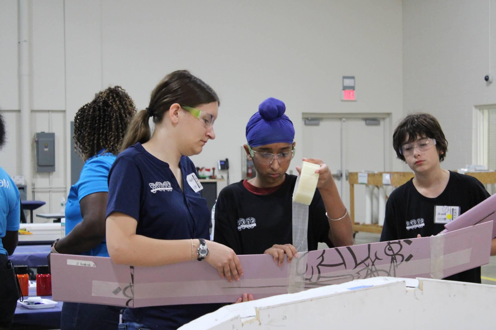 Camper and volunteer taping a STEPS wing.